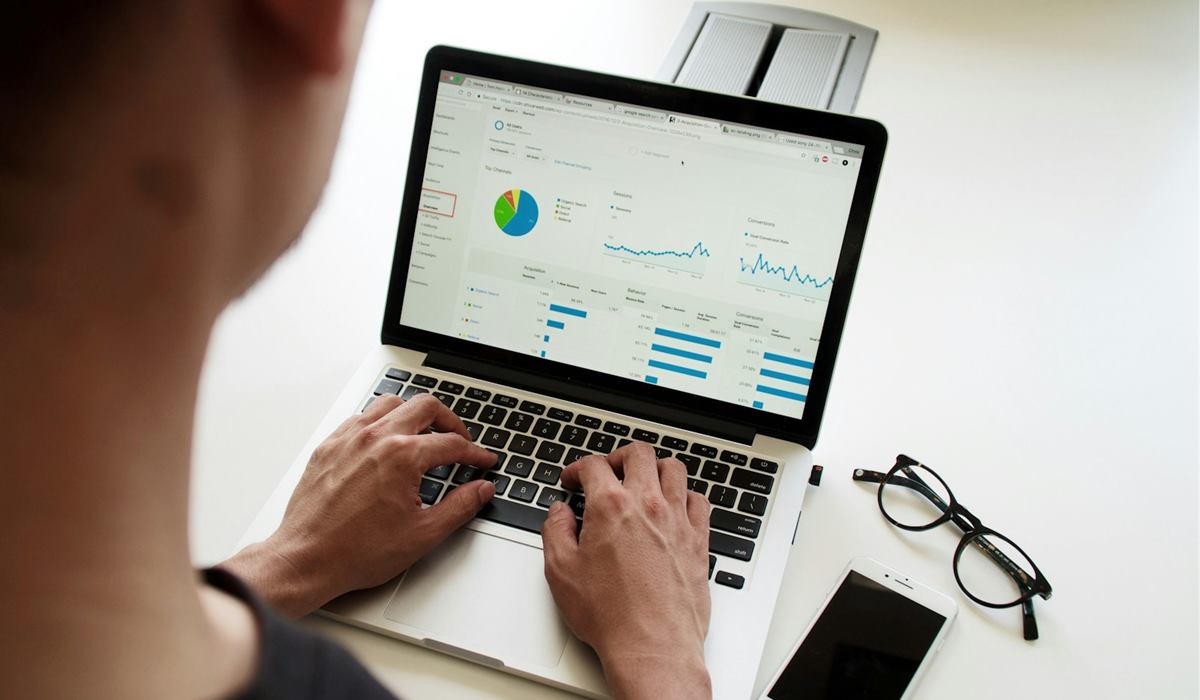 Pessoa analisando gráficos e relatórios em um notebook